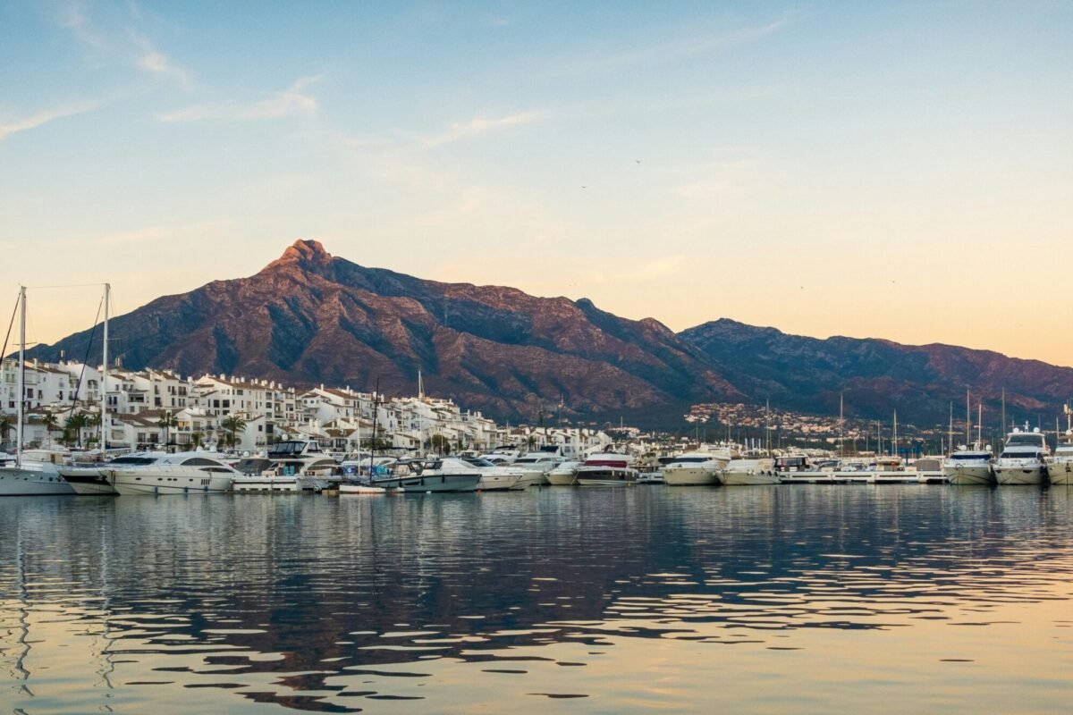 white boats on sea near mountain during daytime