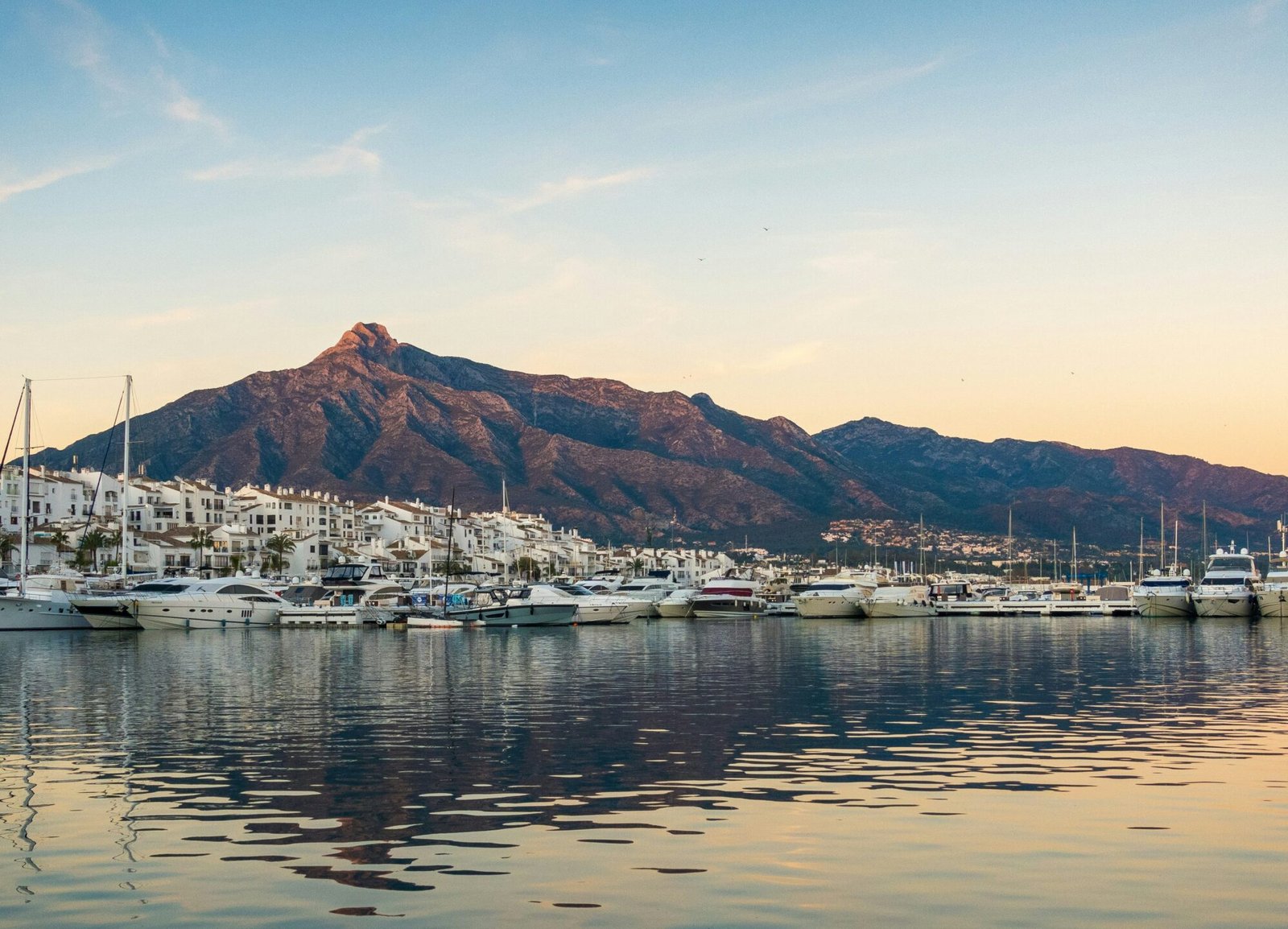 white boats on sea near mountain during daytime